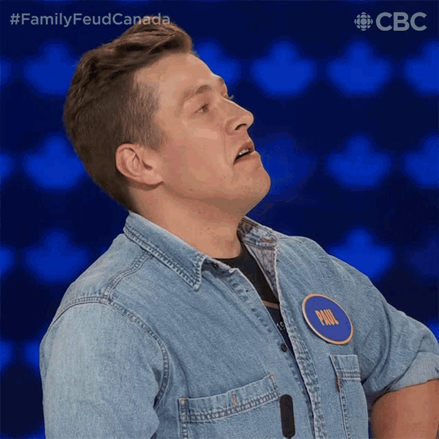 a man wearing a denim shirt with a name tag that says phil