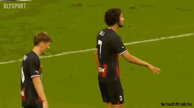 two soccer players shaking hands on a field with blysport written in the corner