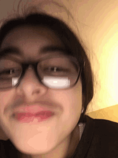 a close up of a woman wearing glasses making a face