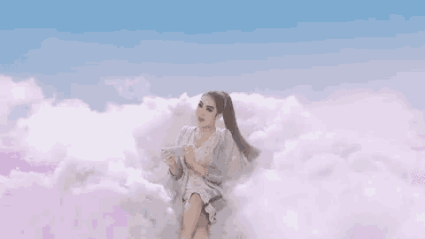 a woman is sitting on a cloud with the words jadi bidadari written above her
