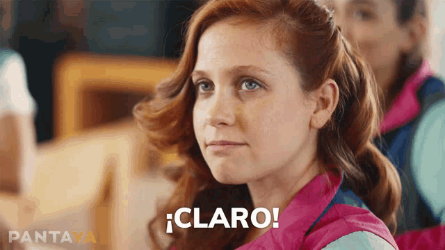 a woman in a pink jacket says " claro " in spanish