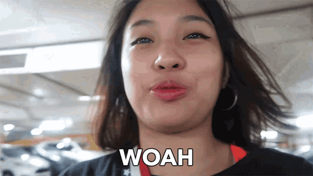 a woman making a funny face with the word woah on her chest