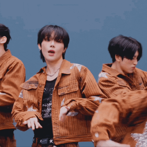 a group of young men are dancing and one of them is wearing a jacket that says converse on it