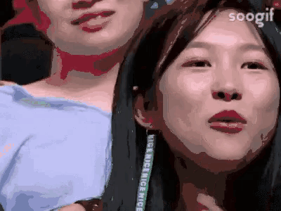 two women are posing for a picture and one of them has a lanyard around her neck that says kiss me nice .