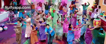 a large group of people are dancing in a room with the website kulfyapp.com on the bottom