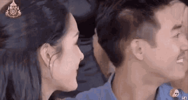 a man and a woman are sitting next to each other on a couch .