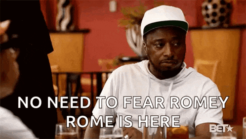 a man is sitting at a table with a woman and saying no need to fear romey rome is here