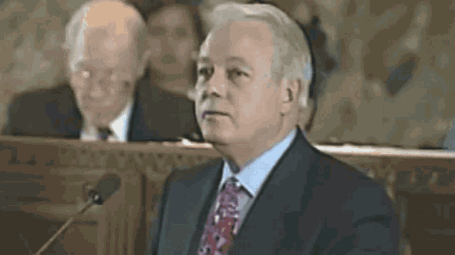 a man in a suit and tie is giving a speech