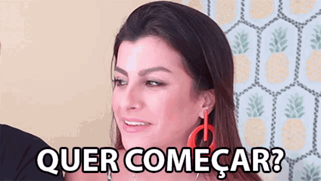 a woman is smiling in front of a pineapple wallpaper and the words quer comecar ? are written below her .