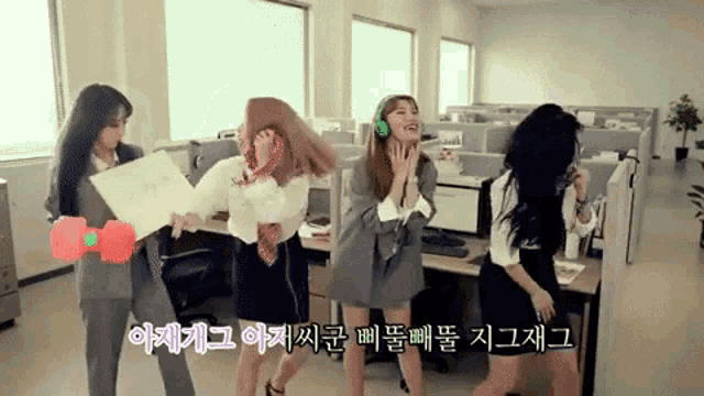 a group of women dancing in an office with korean writing