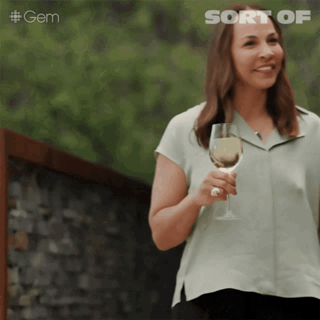 a woman is holding a glass of wine and the word gem is behind her