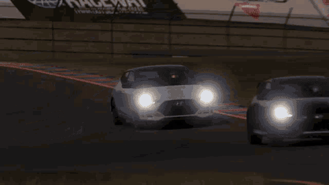 two cars are racing on a race track and one of them is a tesla model s