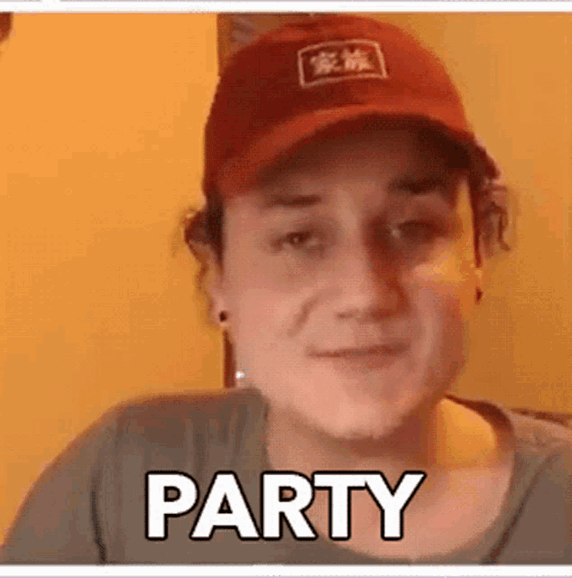 a man wearing a red hat and a gray shirt is smiling and says party .