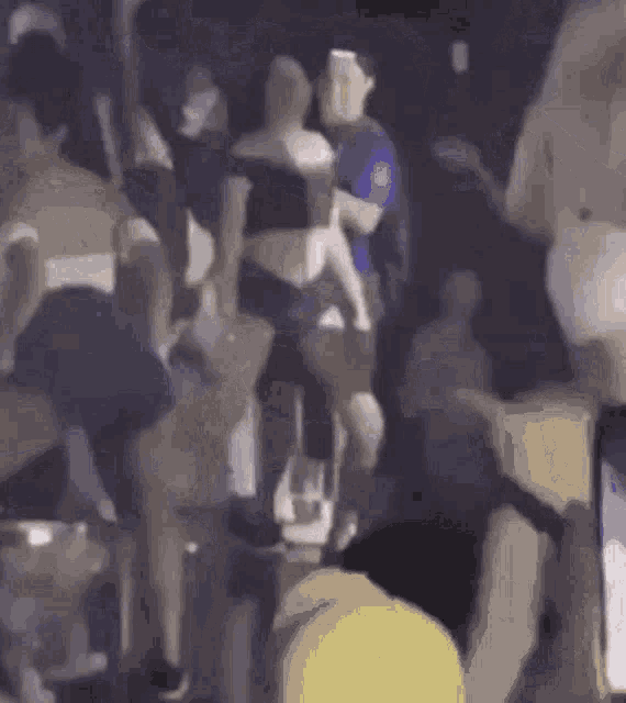 a blurry picture of a crowd of people dancing in a club .