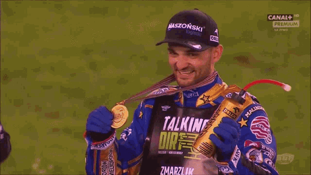 a man wearing a shirt that says talking dirt is eating a medal
