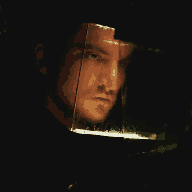 a close up of a man 's face with a reflection of a light