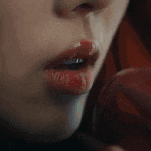 a close up of a woman 's mouth with red lipstick