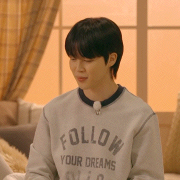 a young man wearing a grey sweatshirt that says follow your dreams