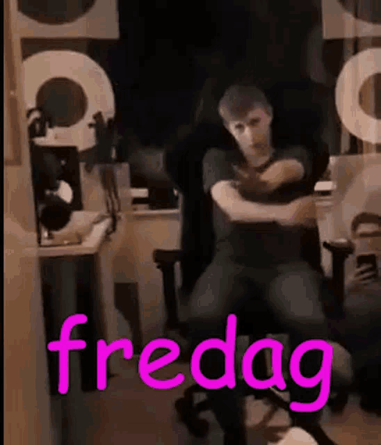 a man is sitting in a chair with his arms outstretched and the word fredag written in pink .