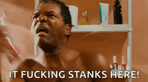 a shirtless man is brushing his teeth in a bathroom and saying `` it fucking stinks here ! ''