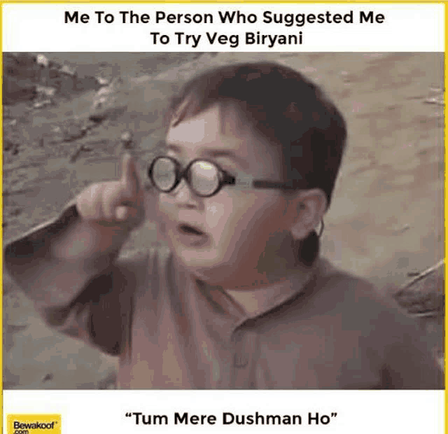 a little boy wearing glasses is pointing up at the camera .