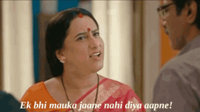 a woman in a pink saree is talking to a man in a white shirt ..