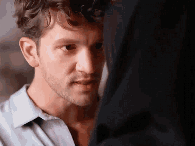 a close up of a man 's face looking at another man 's face