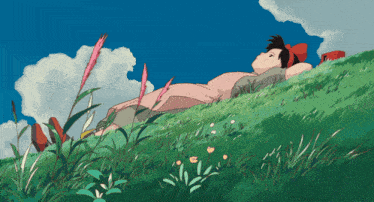 a girl in a pink dress is laying on a grassy hill