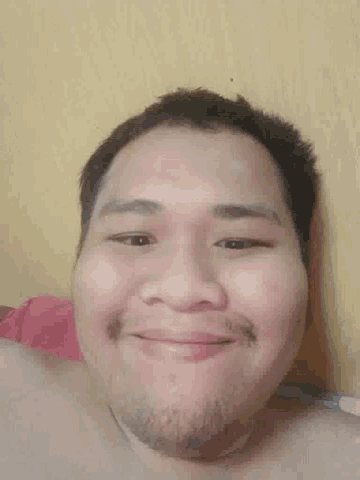 a man with a beard is smiling and looking down