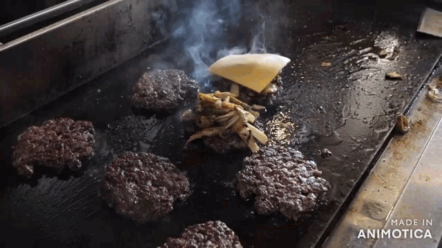 a bunch of hamburger patties are cooking on a grill and the words made in animotica are on the bottom