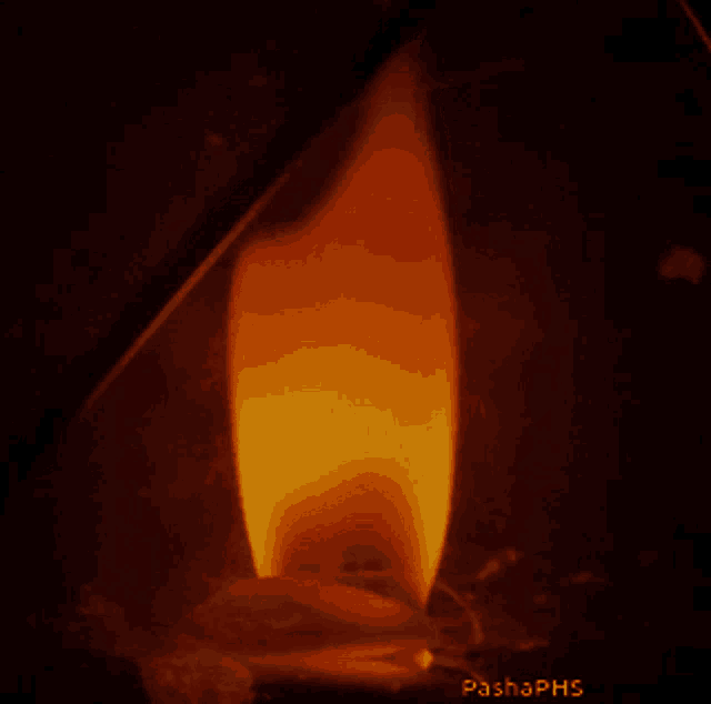 a close up of a candle with pashaphs written on the bottom right