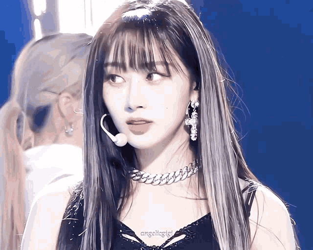 a close up of a woman wearing a choker and earrings with the name angeliigirl on the bottom