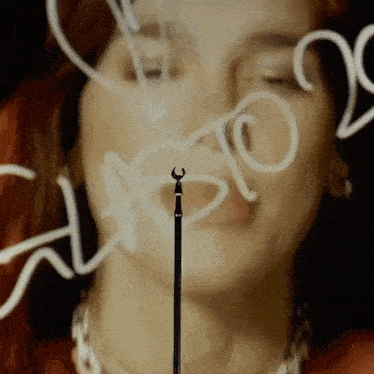 a close up of a woman 's face with the word music written in white