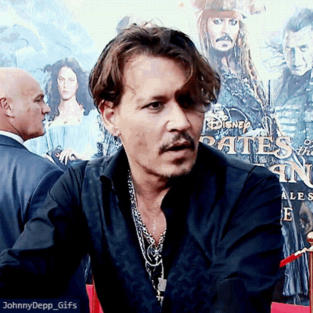 a man sitting in front of a disney poster