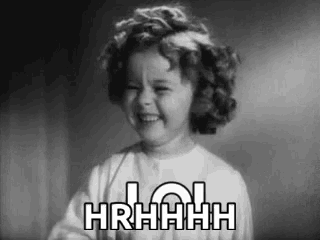 a black and white photo of a little girl laughing with the words hrhhhh written on her face .