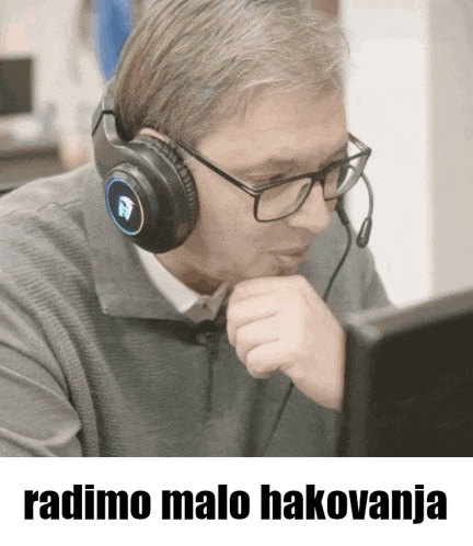 a man wearing headphones looks at a computer screen