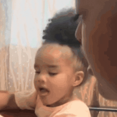 a little girl is being held by a man and making a funny face