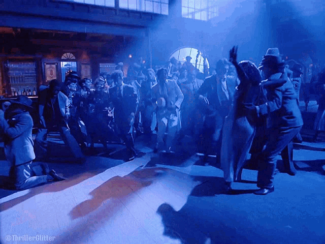 a group of people are dancing in a dark room with the words thrillerglitzer on the bottom right