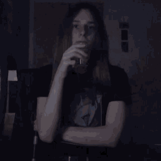 a woman in a black shirt is pouring a drink into a cup