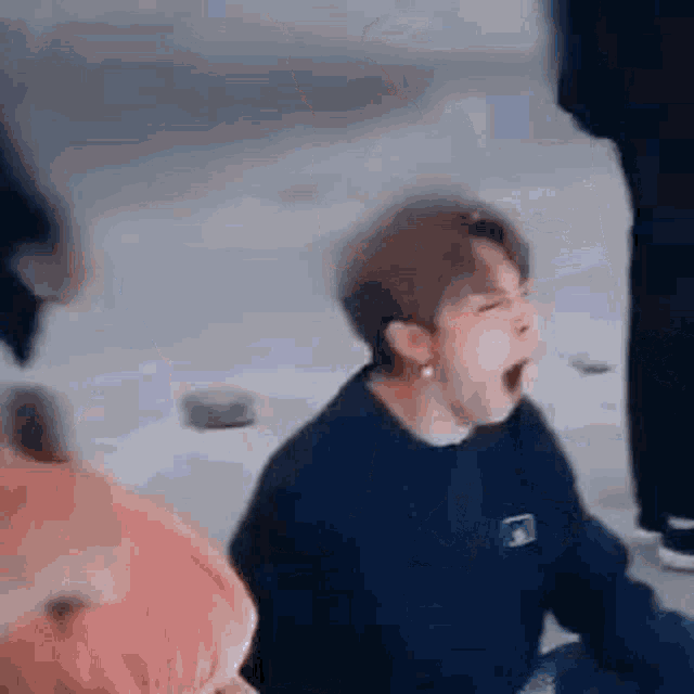 a young man is yawning while sitting on the ground .