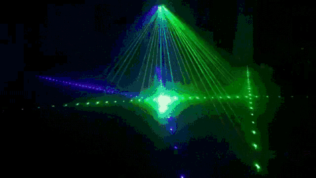 a green and blue light is shining on a dark surface