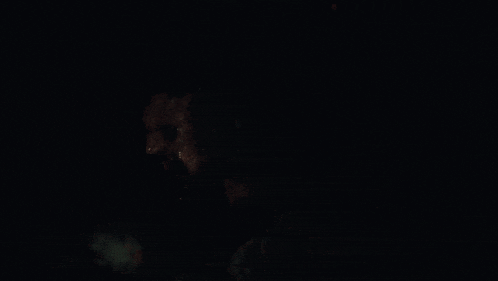 a close up of a person 's face in the dark
