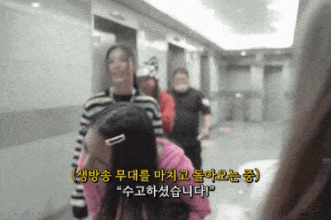 a group of people are walking down a hallway with chinese writing