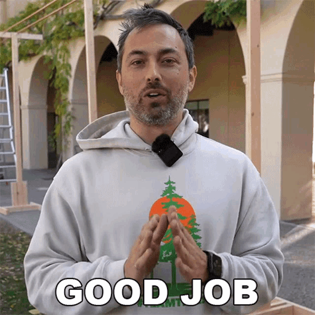 a man wearing a hoodie says good job