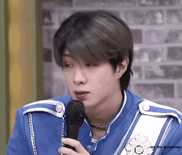 a man in a blue uniform is holding a microphone
