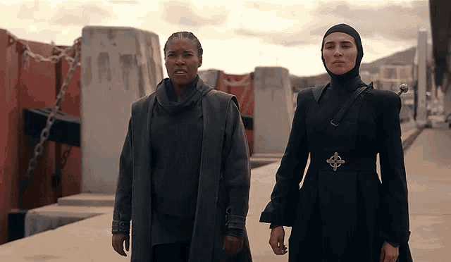 two women standing next to each other with one wearing a celtic belt