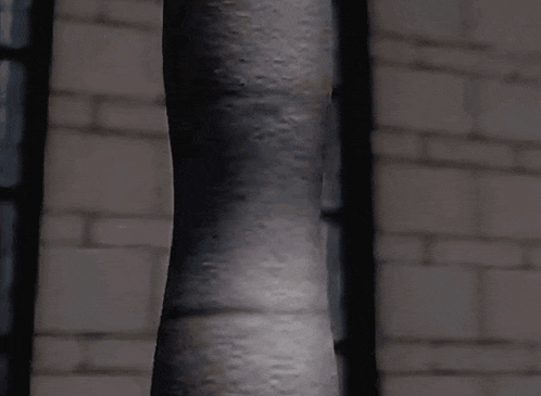 a close up of a person 's face wrapped around a pole .