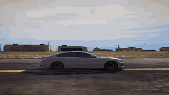 a white car is driving on a runway in front of a building
