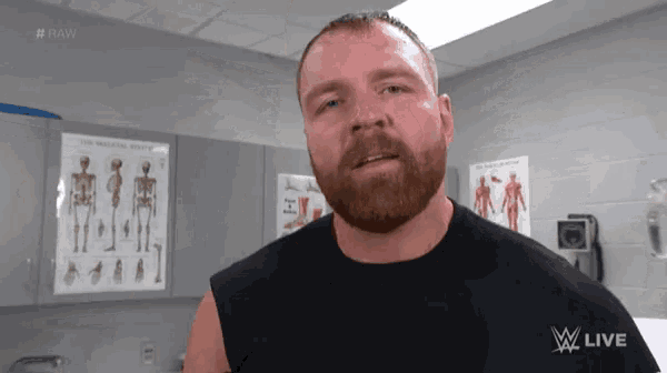 a man with a beard is standing in front of a poster that says raw