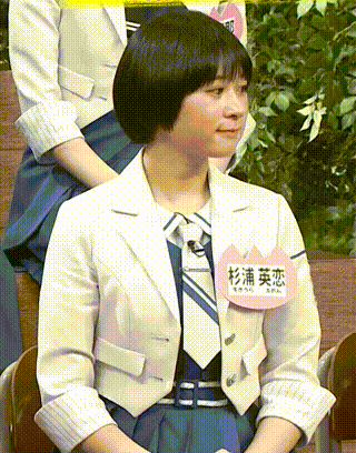 a woman wearing a white jacket and tie has a name tag that says ' a ' on it